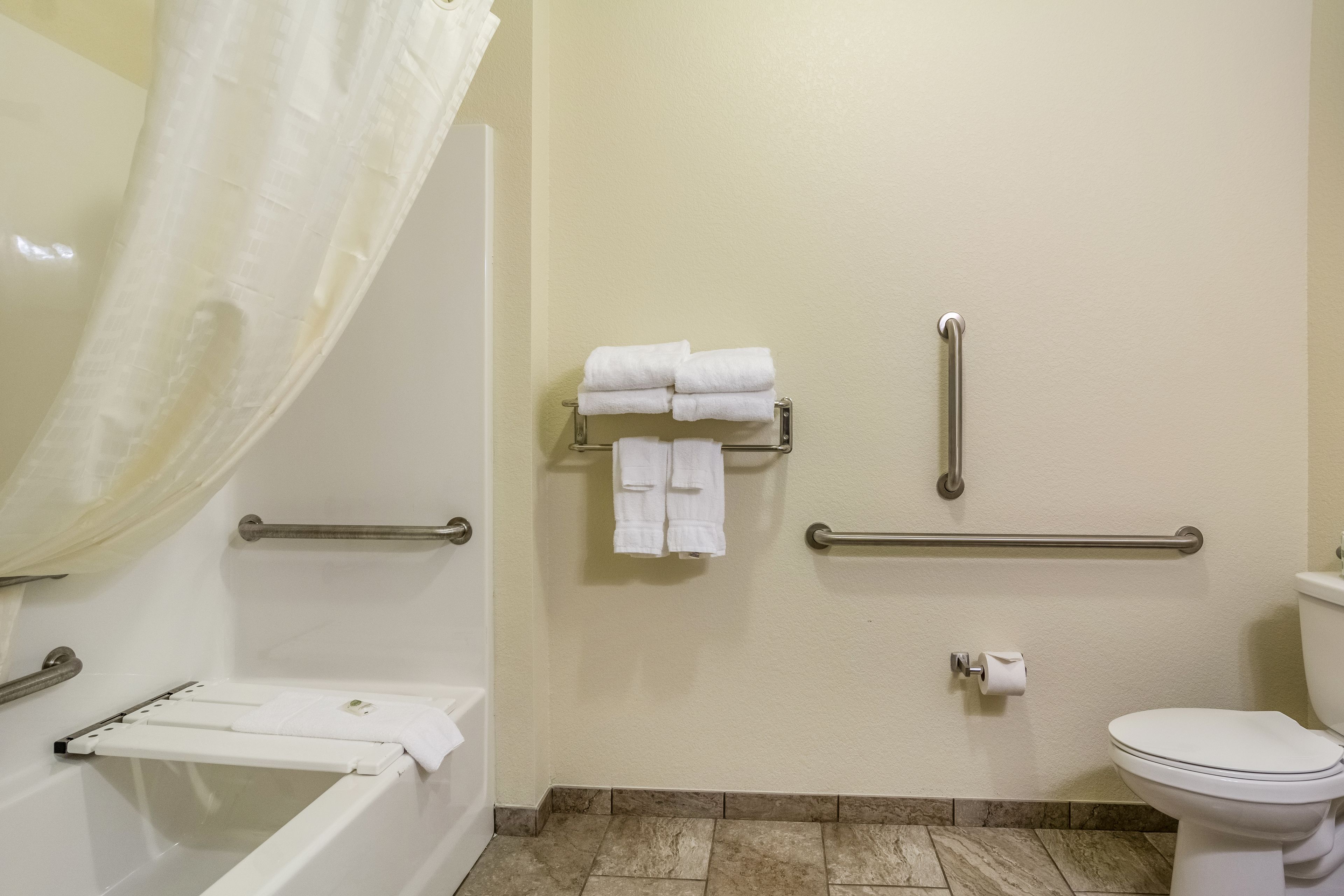 A bathroom with a bathtub, a toilet, and a shower area.