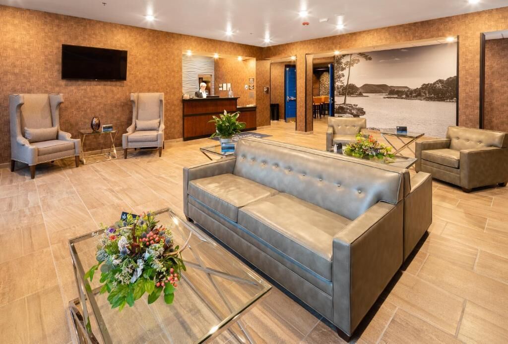 A lobby with a reception desk, seating area, and a large wall-mounted television.