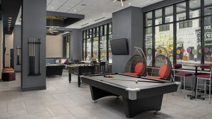 A modern indoor recreational area with a pool table, foosball table, and comfortable seating. - Home2 Suites by Hilton Nashville Downtown Convention Center (Nashville)