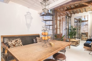 Cozy space with a central dining table, comfortable seating, and a unique chandelier.