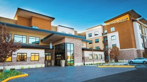 A modern hotel with a prominent "Residence Inn by Marriott" sign, a covered entrance, and a parking area.