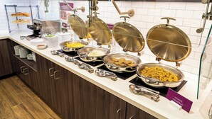 A buffet setup with various food items and cooking stations.