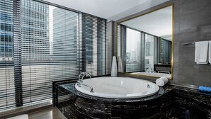 A modern bathroom with a large bathtub, a marble countertop, a large mirror, and floor-to-ceiling windows with blinds. - Hotel Indigo Shanghai Jing'An by IHG (Shanghai)