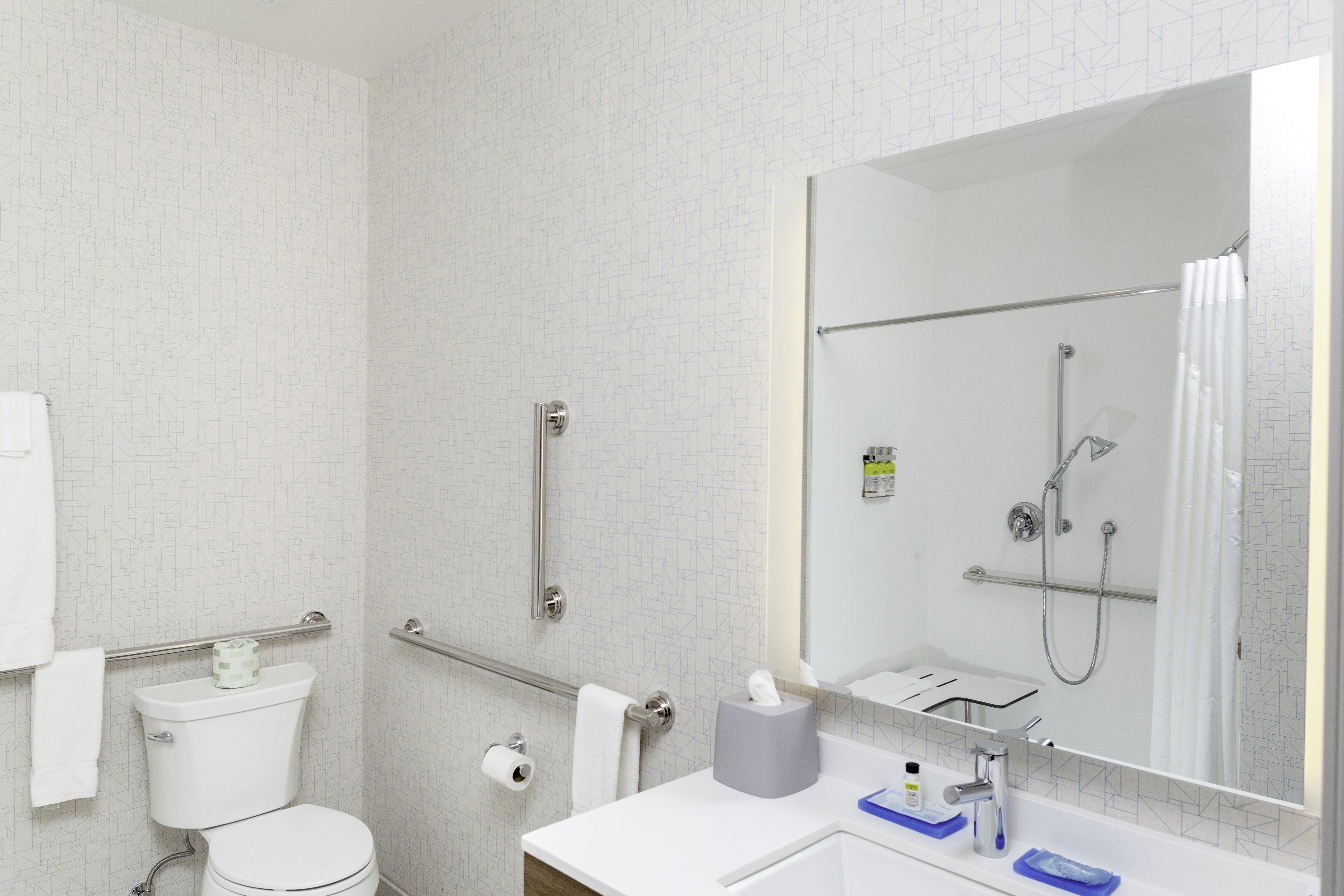 A modern bathroom with a toilet, bidet, and a large mirror.