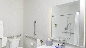 A modern bathroom with a toilet, bidet, and a large mirror.
