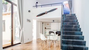 Un interior moderno con una escalera, un comedor y una cocina.