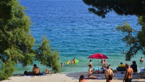 A beach scene with people swimming and relaxing. -  Amadria Park Camping Trogir - Apartments (Seget)