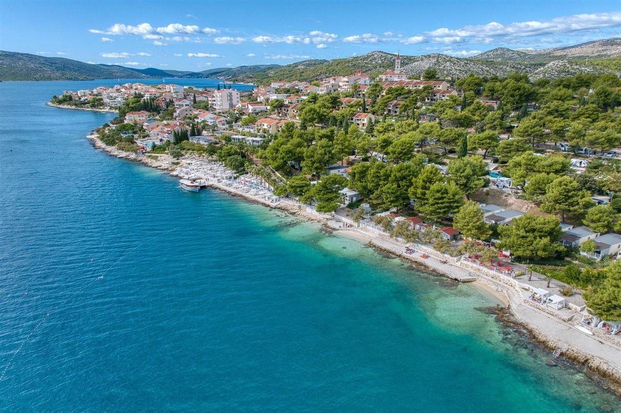 Eine Küstenstadt mit Strand, Häusern und einer Kirche.