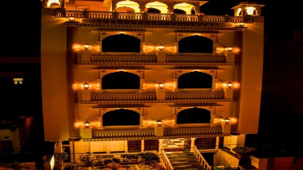 Un edificio de varios pisos con balcones y ventanas iluminadas por la noche.