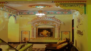 Una habitación de diseño tradicional, con una araña, un cuadro enmarcado y un arco decorativo.