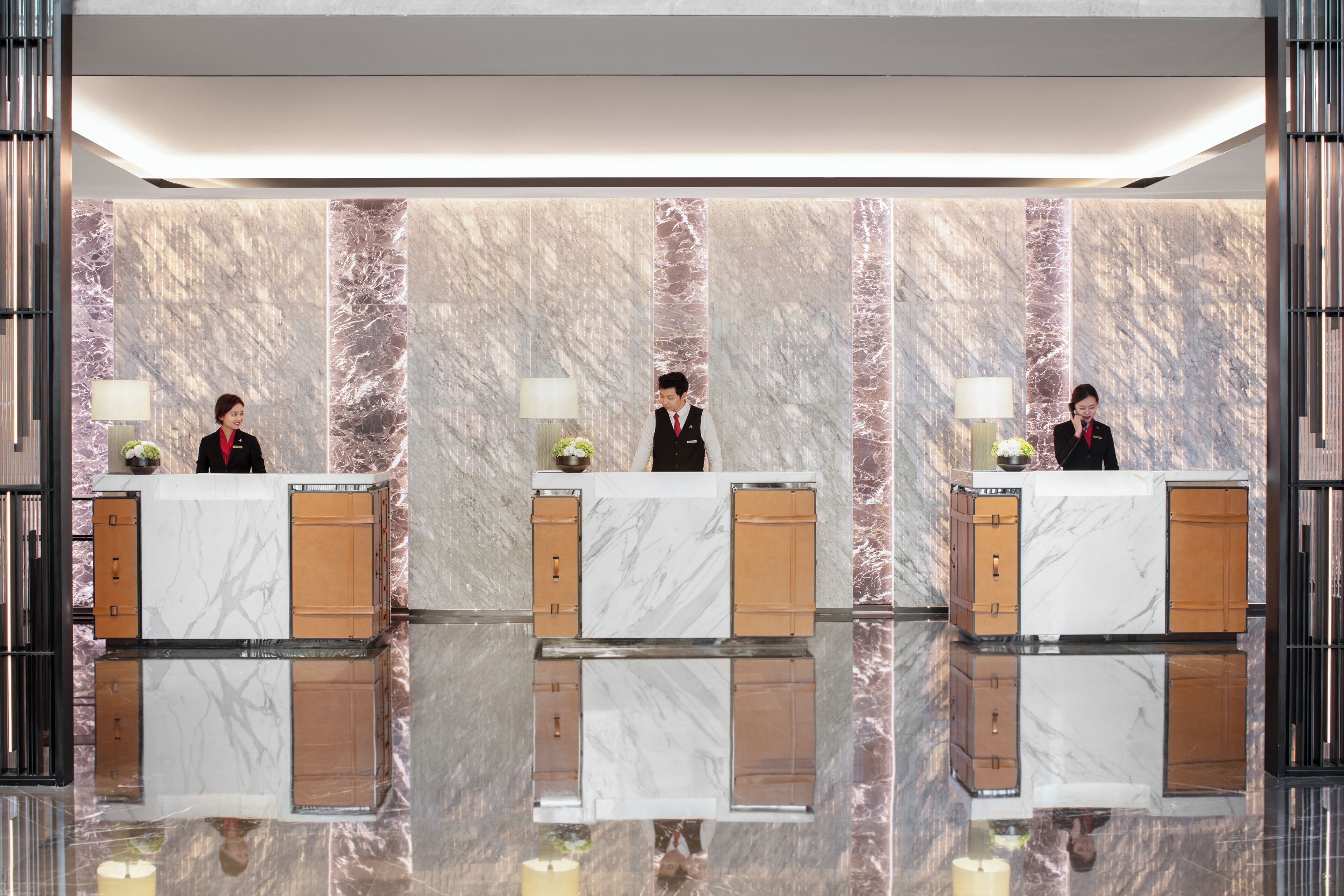 A reception desk with marble walls and a polished floor.