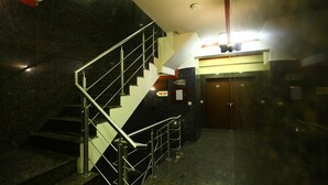 A staircase with metal railings leading to a fire exit. - Hotel Anandam (Gurugram)