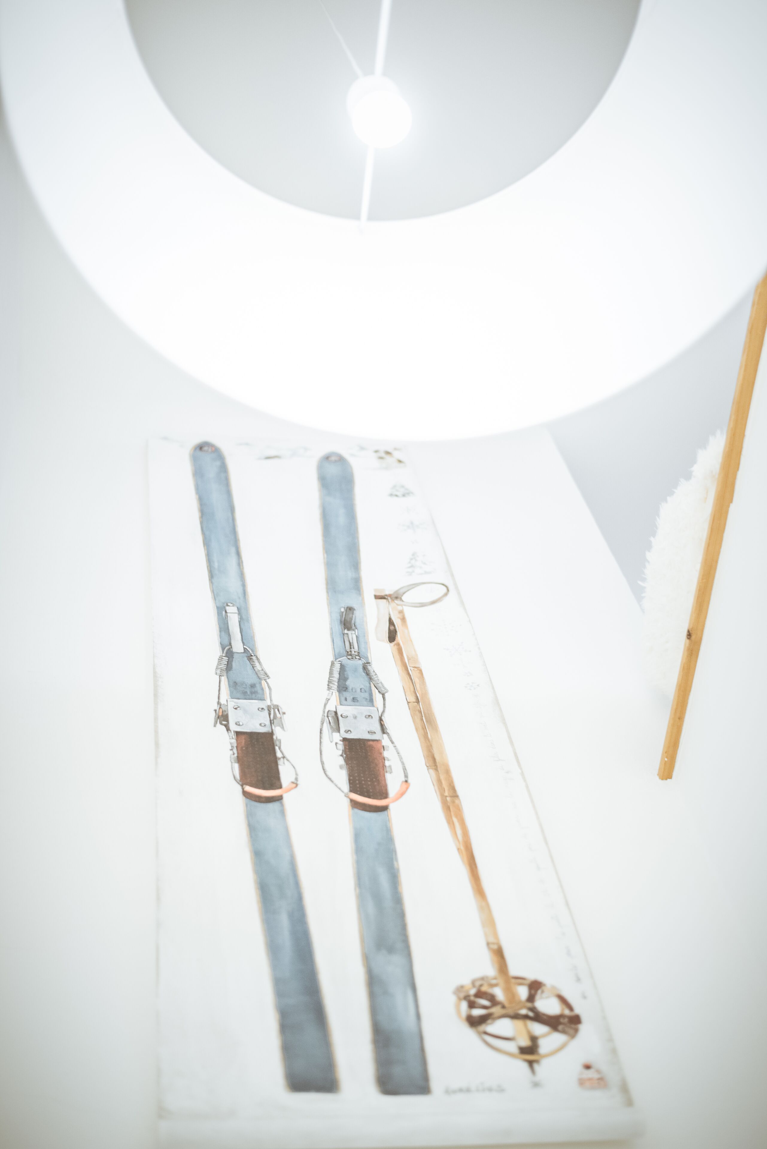 A pair of skis and a ski pole on a white surface.
