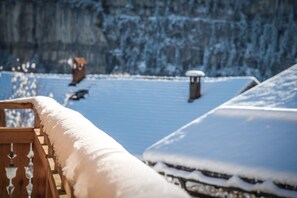 A snow-covered deck with a wooden railing and a snow-covered roof. - Lifestyle Rooms & Suites by Beau-Séjour (Champery)