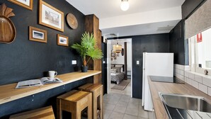 Een moderne keuken met houten aanrecht, een spoelbak en een eethoek met krukken.