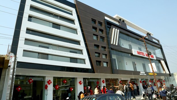 A modern hotel building with multiple floors, large windows, and a prominent sign for the hotel.