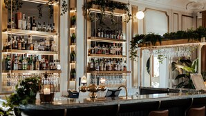 A bar area with shelves of liquor bottles, a bar counter, and seating. - Haga Slott (Enkoping)