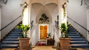 A grand staircase with a wooden door at the top, flanked by two large potted plants. - Haga Slott (Enkoping)