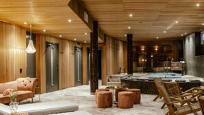 A modern spa area with a massage table, seating, and a hot tub. - Haga Slott (Enkoping)