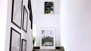 A staircase with a rustic wooden finish, leading to a landing where framed pictures are displayed on the walls. - xinyi (Huairou)