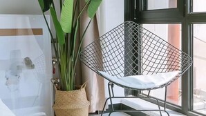A room with a large window, a metal chair, a potted plant, and a bed. - xinyi (Huairou)