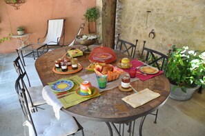 Guests can dine al fresco at this outdoor setting, surrounded by comfortable seating and a beautifully set table.