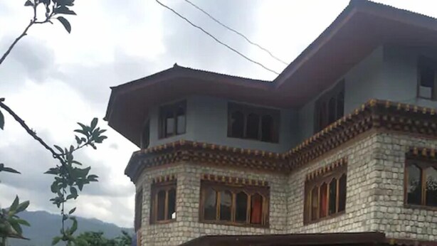 A two-story stone building with a balcony and a garden in front. - Ngayabling Resort (Paro)