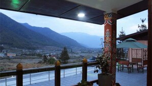 A balcony with a view of mountains and a river. - Soenam Tsokhang Resort (Paro)