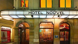 Un edificio histórico con un cartel luminoso que dice 'HOTEL NOUVEL'.