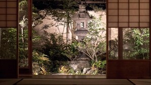 A traditional Japanese room with tatami flooring, a shoji screen door, and a view of a serene garden with a stone lantern. - HANARé Genmachi (Kyoto)