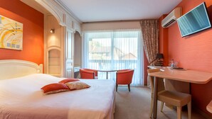 A hotel room with a bed, a desk, two chairs, a TV, and a window with curtains. - Logis Auberge du Cheval Blanc (Westhalten)