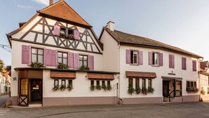 A traditional half-timbered building with a sign reading "CHEF'S RESTAURANT" and a door with a small awning. - Logis Auberge du Cheval Blanc (Westhalten)