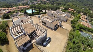 A residential area with multiple houses, a swimming pool, and a mountainous backdrop. - Exclusive Villa with Sea View – Rio nell’Elba: Villetta Natura Casa A (Rio nell'Elba)