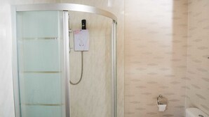 A shower with a glass door, a control panel, and a toilet with a paper towel holder. - Bradford City Apartments Flat 74 (Bradford)