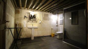 A bathroom with a sink, toilet, and shower area.