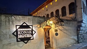 L’extérieur de l’hôtel Aynurhanim Konak, avec sa façade en pierre et son panneau indicateur.