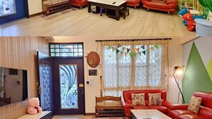A living room with a red sofa set, a coffee table, and a decorative wall. - Dao Siang Hai B&B (Taitung)