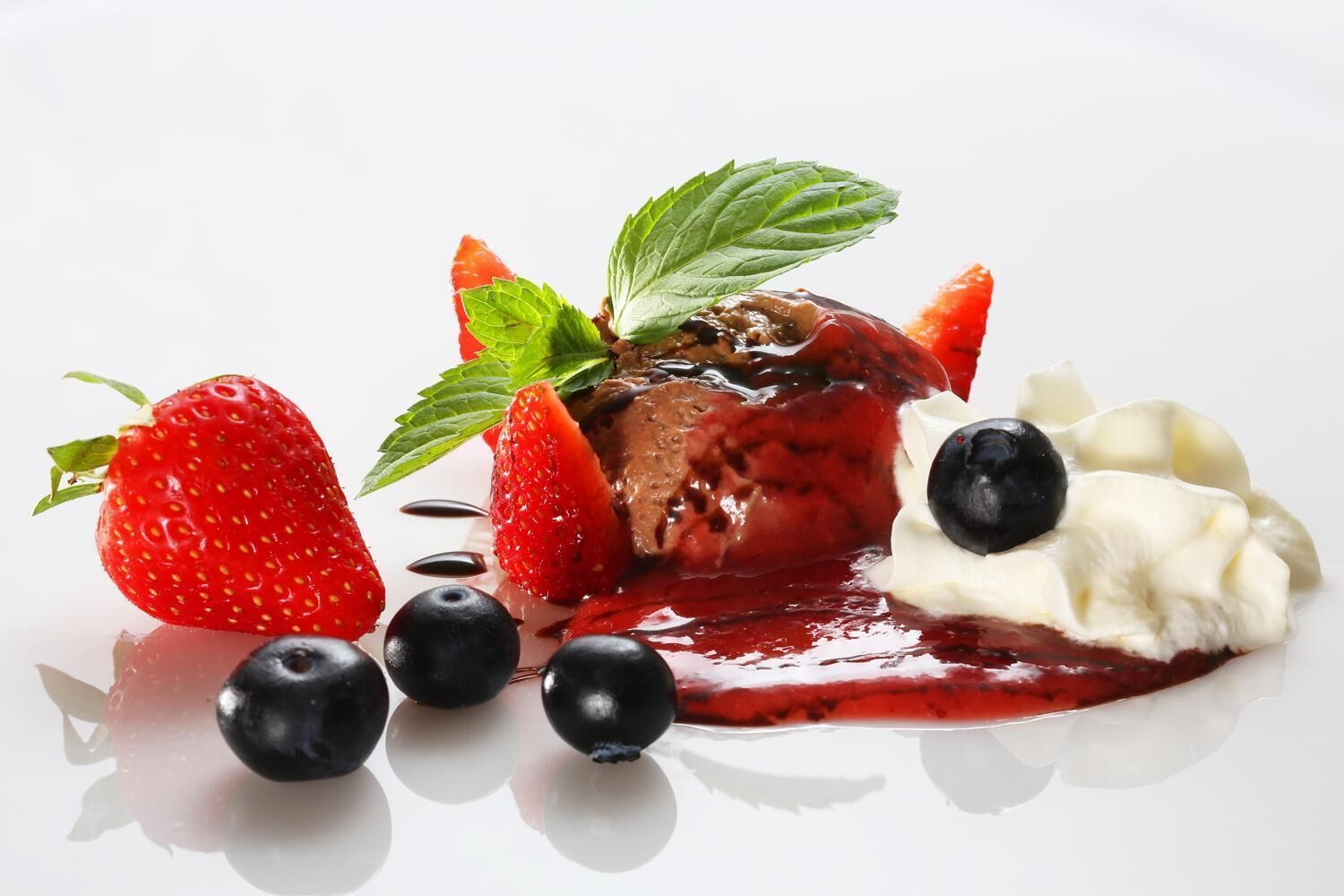 A dessert with strawberries, blueberries, and whipped cream.