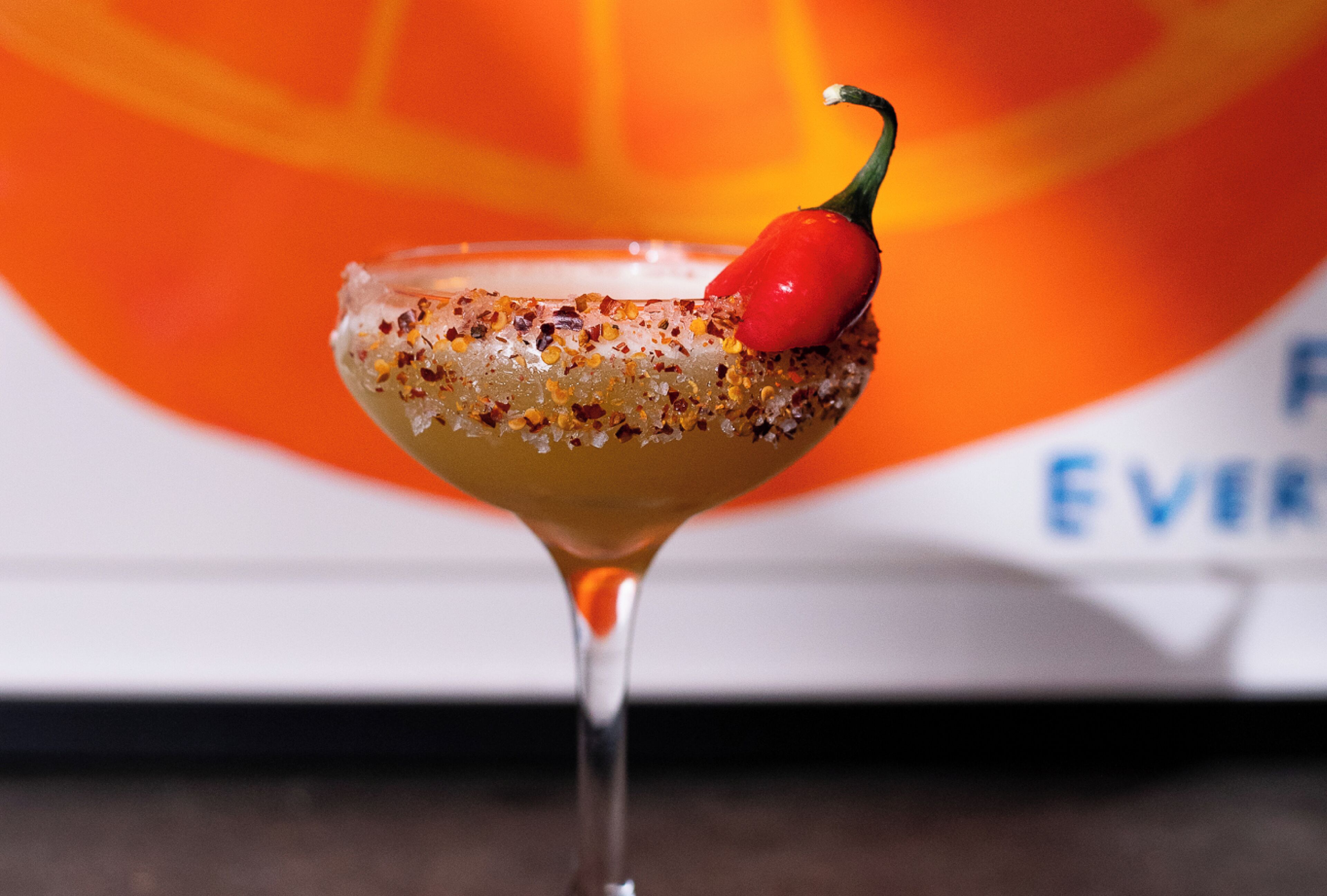 Ein Cocktail mit Chili-Garnitur in einem Martini-Glas.