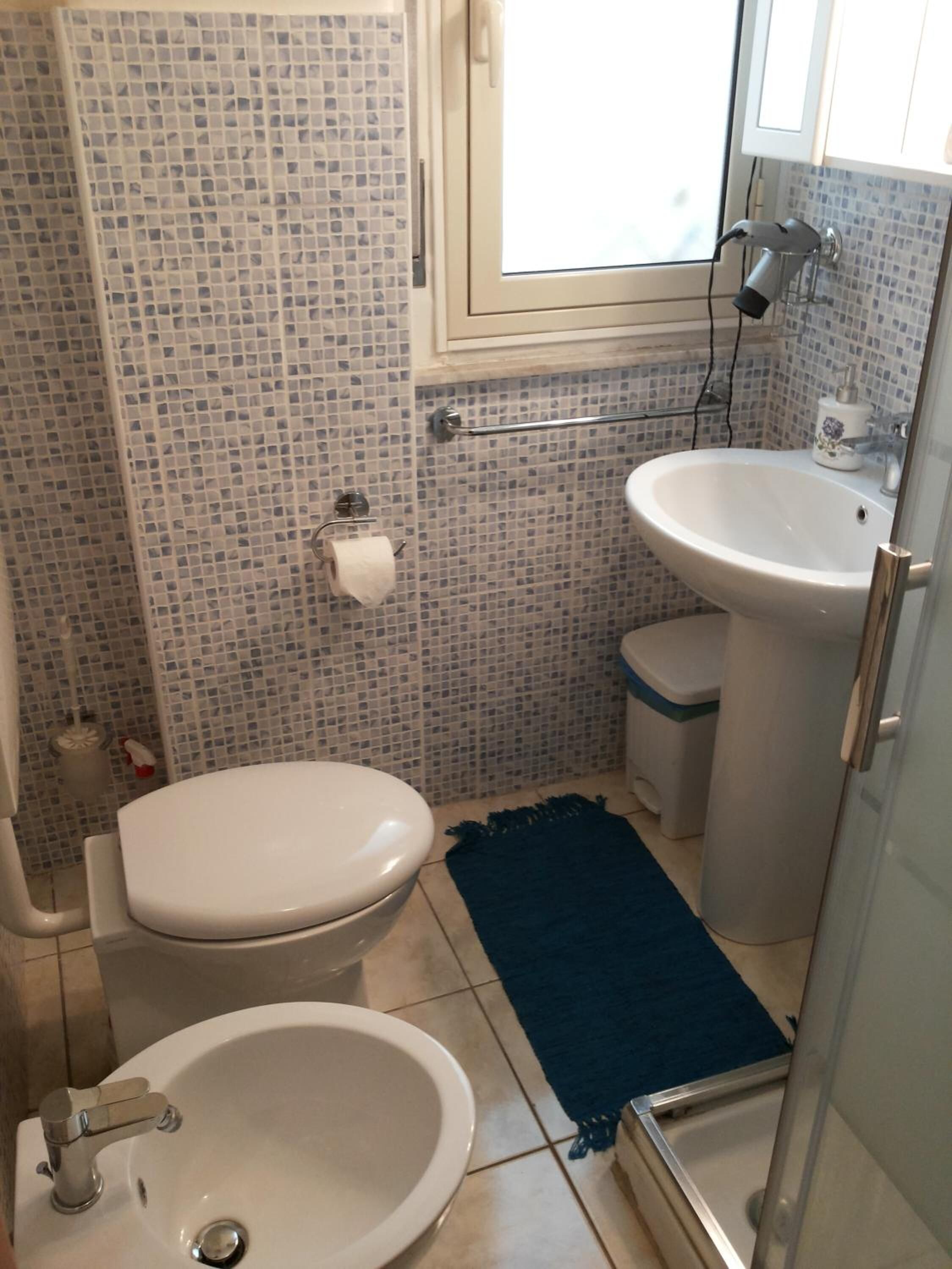 Un bagno con WC, lavandino e doccia.
