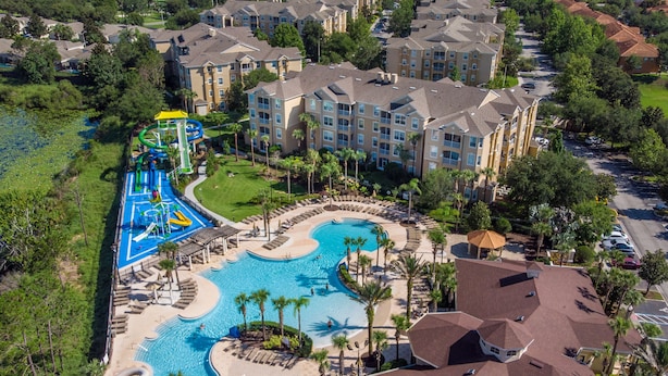 Eine Vogelperspektive zeigt ein Resort mit einem großen Schwimmbecken, einem Wasserpark und mehreren Hotelgebäuden.