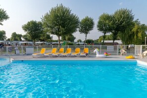 En säsongsöppen utomhuspool, parasoller och solstolar