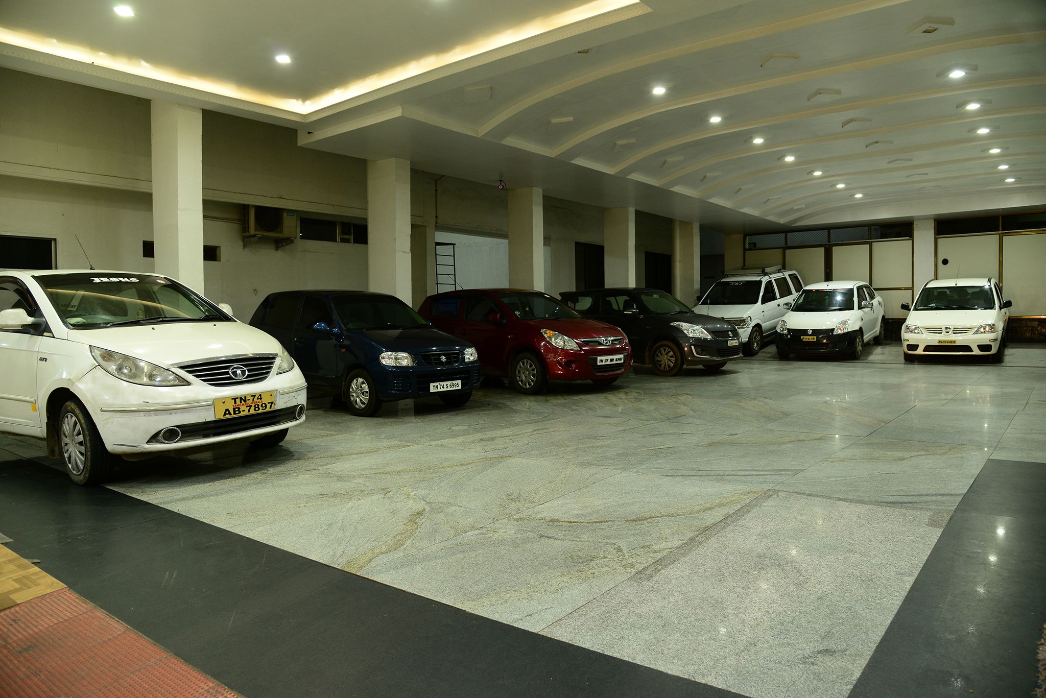 Un aparcamiento con varios coches estacionados en filas.