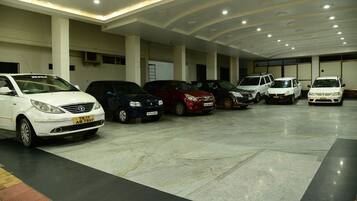 A parking garage with multiple cars parked in rows.