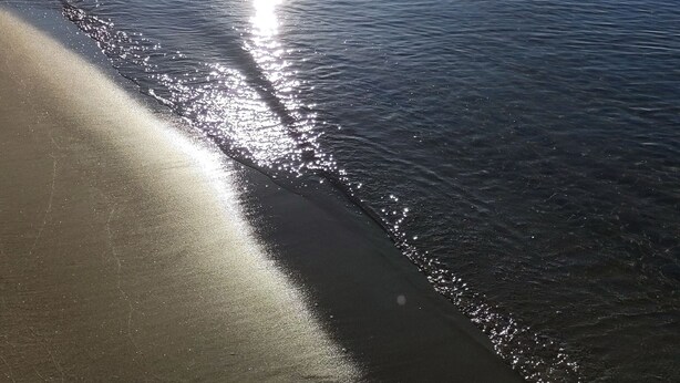 A beach with calm water reflecting sunlight, a clear sky, and a visible horizon. - Sedilequattro Bed&Breakfast (Castellaneta)