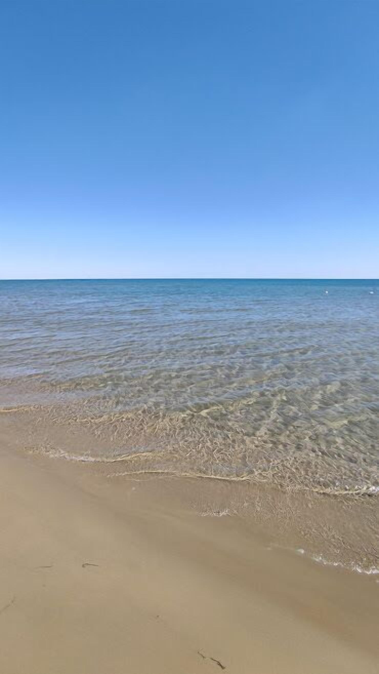 Une plage à l’eau claire et au rivage sablonneux.