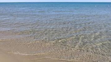 Une plage à l’eau claire et au rivage sablonneux.