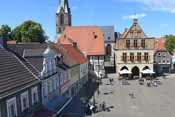 Una plaza histórica con adoquines, edificios tradicionales y una torre de iglesia.