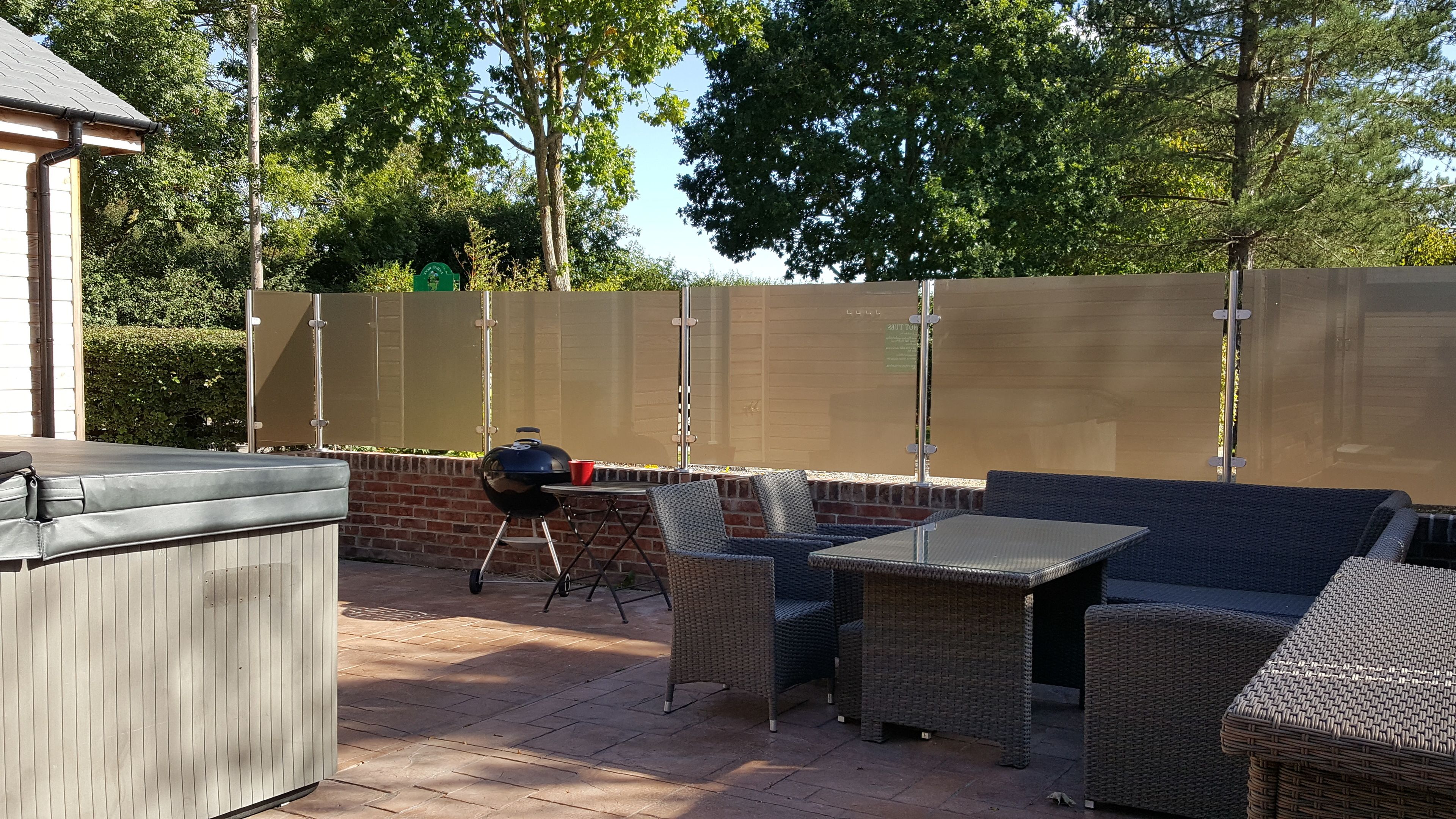 Une terrasse extérieure équipée d’un barbecue, de sièges et d’un espace abrité.