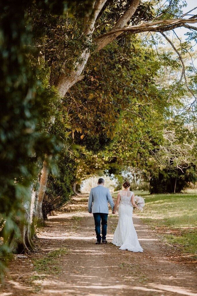 A couple walking down a tree-lined path.